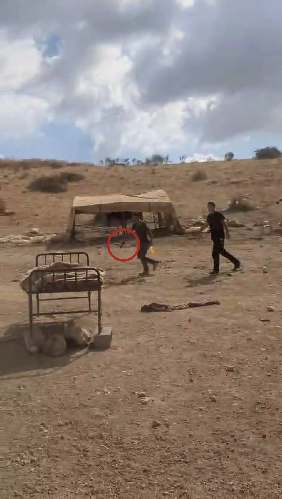 An Israeli settler drawing a gun at Palestinians in Wad al-Fau